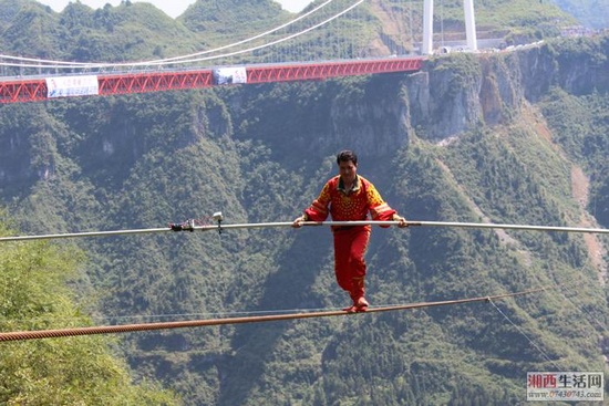 Adil challenges high-wire walking above Aizhai canyon