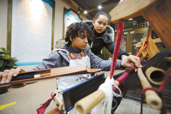 Overseas Volunteers Try Tujia Brocade in Zhangjiajie